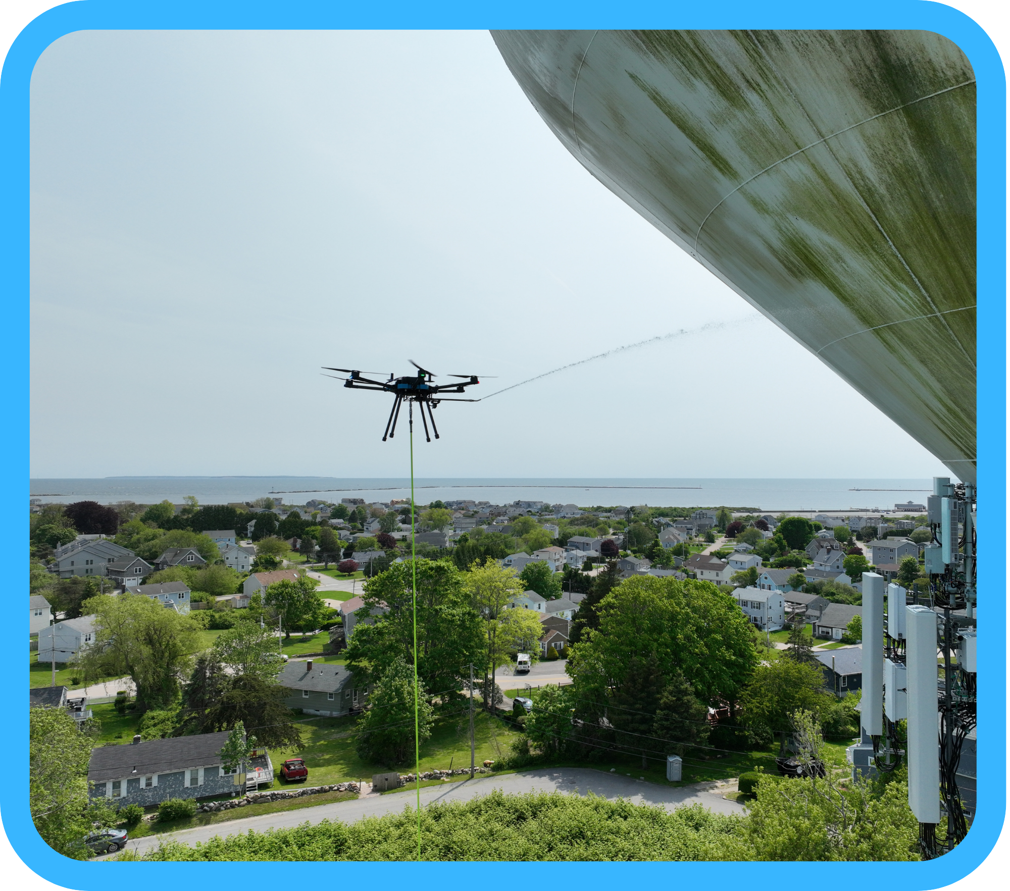 Drone hovering at water tower performing cleaning